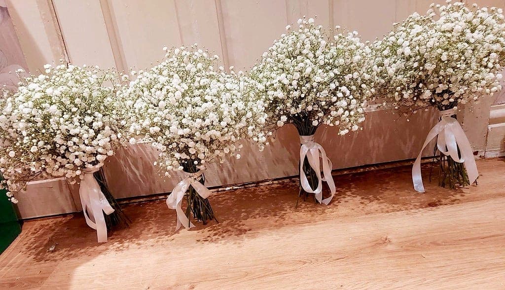 Four matching gypsophila wedding bouquets tied with white satin ribbon