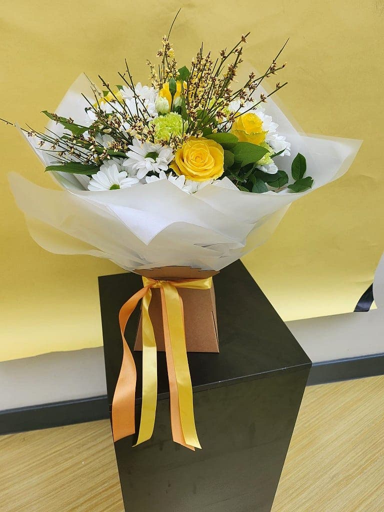 Yellow rose gift bouquet in a kraft box with orange and yellow ribbon